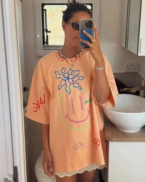 Woman wearing an orange organic cotton adult t-shirt with hand-drawn illustrations by Yolky Club
